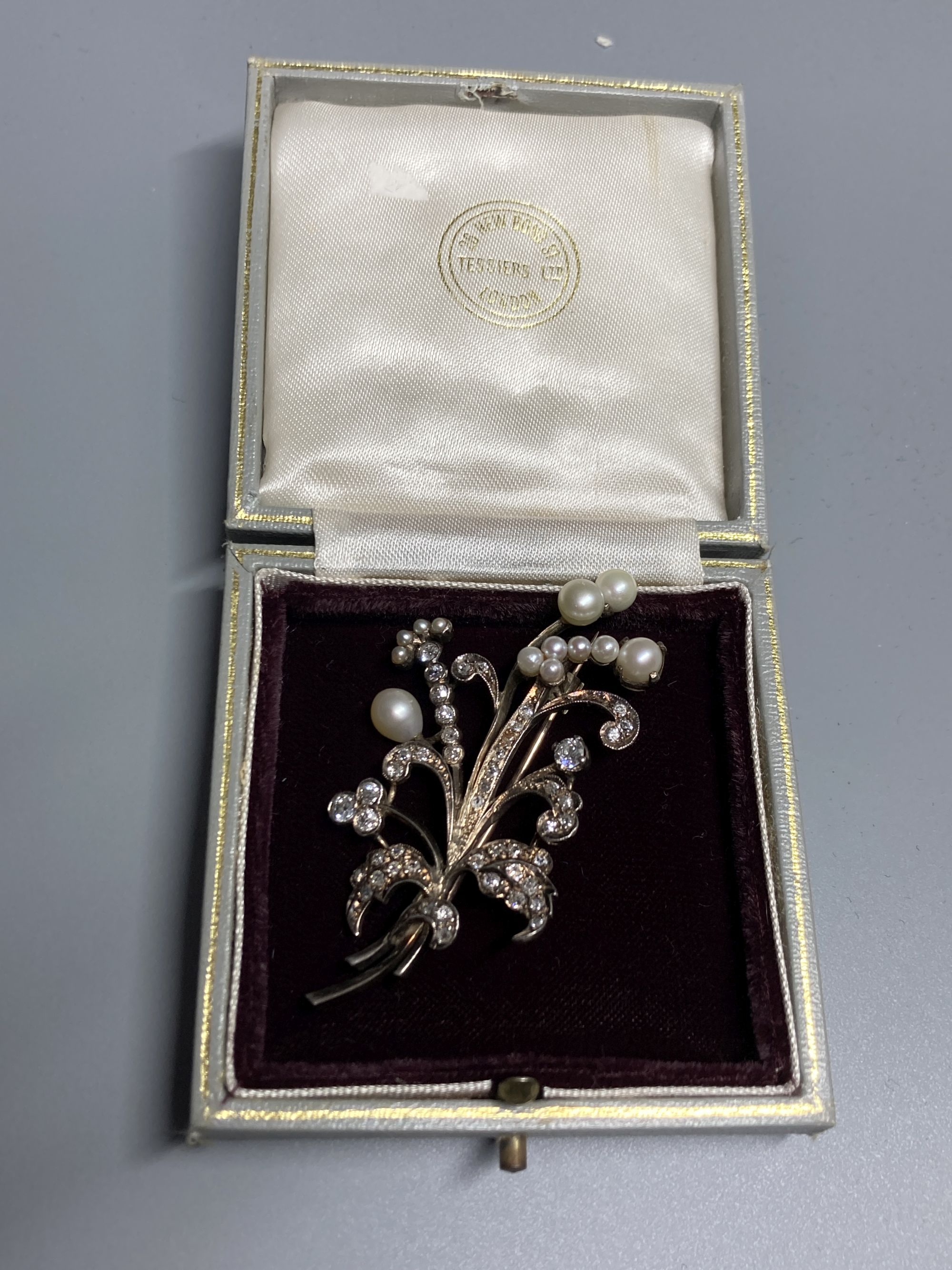 An early 20th century yellow and white metal, cultured pearl and diamond set floral spray brooch, 6cm, gross 12.6 grams.